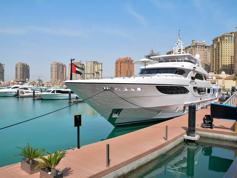 Private Yacht Cruise The Pearl-Qatar — luxury yacht at sunset beside Porto Arabia marina Doha